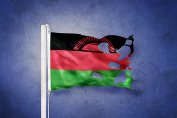 Torn flag of Malawi flying against grunge background