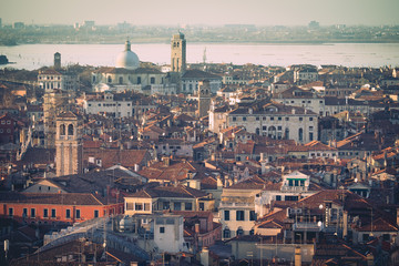 Fototapeta premium Aerial view of Venice, Italy, at sunset with rooftops of buildings and vintage colors in winter afternoon.