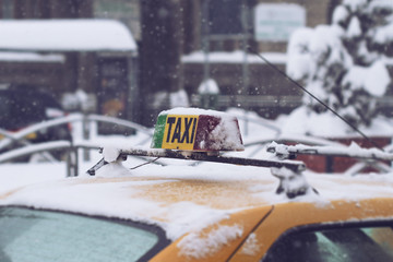 close up of taxi covered in snow in the city