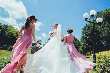 happy Bride with bridesmaids in the park on the wedding day