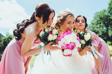 happy Bride with bridesmaids in the park on the wedding day