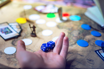 hand throws the dice on background world map Board games