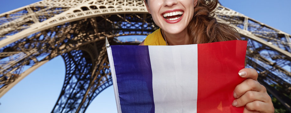 Closeup on smiling young woman showing flag in Paris, France