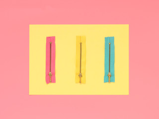 Three zippers on pink background. Flat lay concept, top view. - 134707437