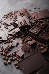 Broken slices of chocolate and coffee beans. Chocolate chocolate chunks. Chocolate bar pieces. A large bar of chocolate . Background with chocolate