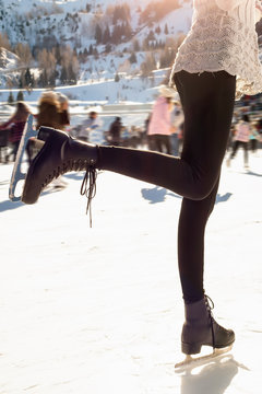 Pretty woman ice skating winter outdoors, smiling facial. mountains in the background