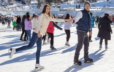 Loving couple skating together holding hands