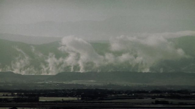 Clouds Rise from Warm Mountain Reservoir Water on Cold Winter Day