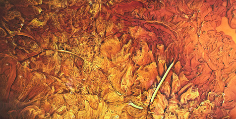 Red and yellow oil paint mixed flows, top view