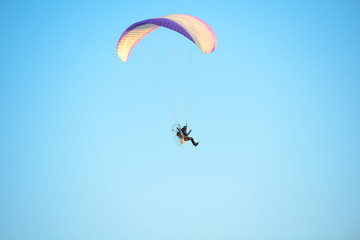 adventure man active extreme sport pilot flying in sky with paramotor engine glider parachute