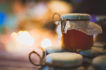 many jars of honey drawn a pyramid in the background lit candles