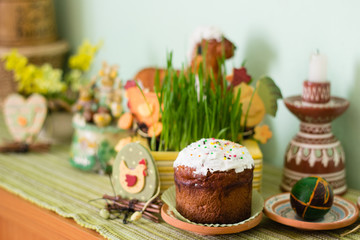 Easter bread on decorated table with eggs and green grass