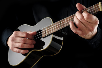 Fototapeta na wymiar musician playing black ukulele
