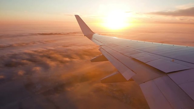 Aerial view of sunrise through airliner window
