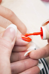 Manicure specialist care by finger nail in beauty salon.