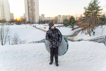 The boy with the tubing is on background of city