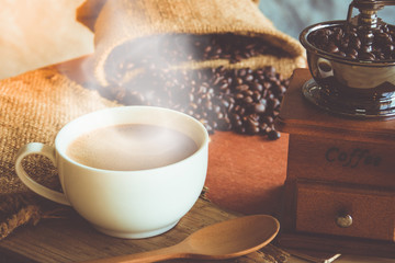 A cup of black coffee in white cup with coffee bean in sack bag