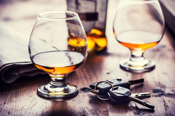 Alcoholisme. Beker cognac of cognac hand man de sleutels van de auto en onverantwoordelijke bestuurder.