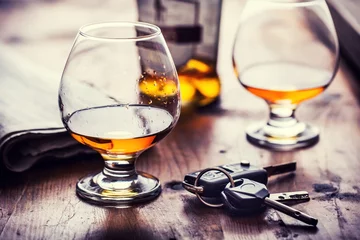 Fotobehang Bar Alcoholisme. Beker cognac of cognac hand man de sleutels van de auto en onverantwoordelijke bestuurder.