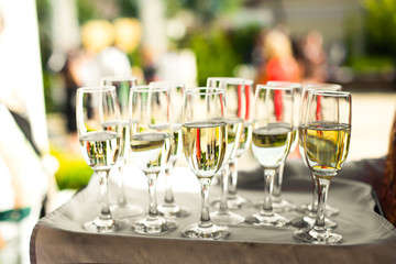 Glasses with champagne sparkle on tray covered with white napkin