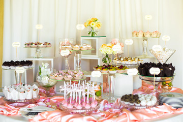 Beautiful candy bar covered with pink silk and served with glass