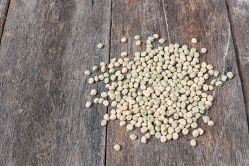 Obraz na płótnie Canvas dry sugar pea seed, green nuts on the wood board background.