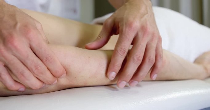 Physiotherapist giving hand massage to a woman in clinic