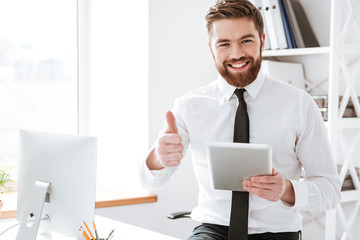 Businessman holding tablet and make thumbs up gesture.
