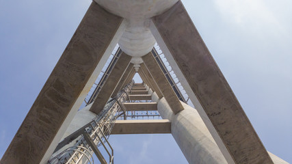 Concrete constructure and metal ladder up to the top with blue sky.