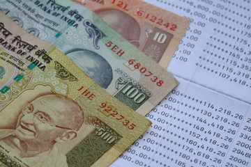 Indian rupee banknote on bank statement, saving investment concept