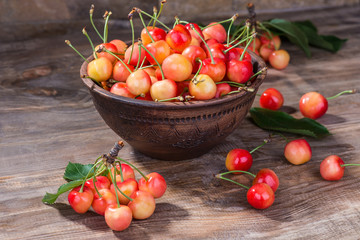 Fragrant and ripe cherries in a plate on a wooden background. selective focus