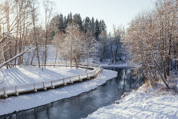 Winter park with snow trail and river at sun day