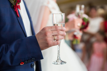 Married man holds glass with champagne