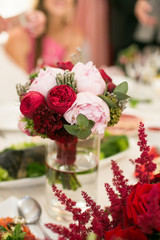 Little bouquet of peonies stands in tall vase with water