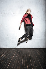 Picture of emotional young bearded hipster man jumping