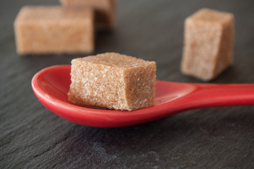 sucre de canne et cuillère rouge sur ardoise