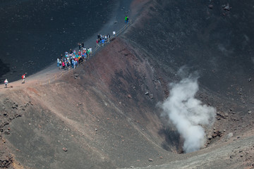 Turisti ammirano una cratere sul vulcano Etna in Sicilia © amorando