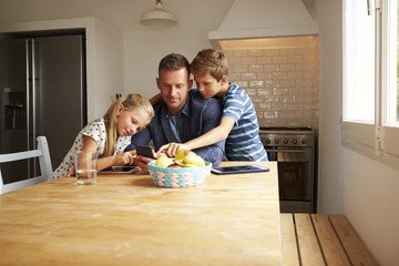 Fototapeta premium Children Looking At Mobile Phone With Father