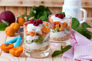 Fresh fruit salad with glass of apple and carrot juice on old wooden table. Eco food vitamins background