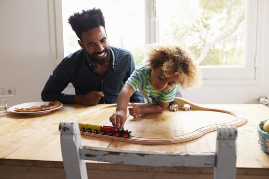 Father And Son Playing With Toy Train Set