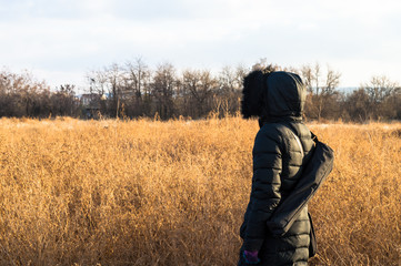 Naklejka na ściany i meble Woman in black standing alone in a field