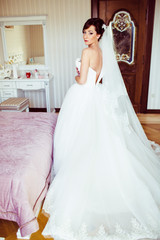 Naklejka premium The beautiful bride stands near bed