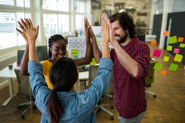Team of business executives giving high five