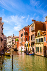 Traditional narrow canal with gondolas in Venice, Italy