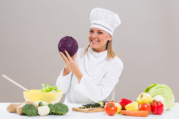 Female chef showing cabbage while making healthy meal