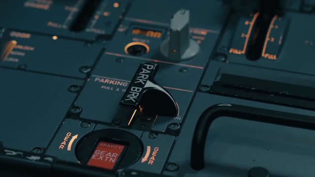 Prepare to taxi, take off and departure. Close shot of cabin interior of Airbus A319 A320 A321. Flight deck and pedestal. Professional pilot hand switch park brake control