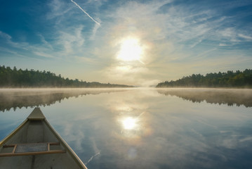 Canoe trip in the morning.  Brilliant and bright mid-summer sunshine morning, paddling a canoe in the middle of quiet, calm and peaceful Corry lake.