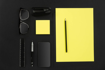 Top view of office supplies on blackboard background with copy space.