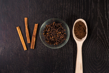 cinnamon sticks, coffee, cloves on black background