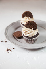Homemade dark chocolate cupcakes with cookie and cream frosting